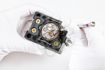 watchmaker workshop - repairing of mechanical watch with screwdriver on white background