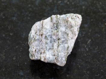 macro shooting of natural mineral rock specimen - rough Apatite ore on dark granite background