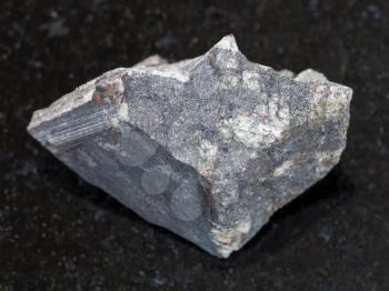 macro shooting of natural mineral rock specimen - rough porphyritic Basalt stone on dark granite background