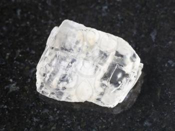 macro shooting of natural mineral rock specimen - rough crystal of Petalite gemstone on dark granite background from Araguaia mine, Brazil
