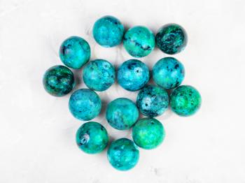 top view of beads from natural Chrysocolla gemstone on gray concrete background