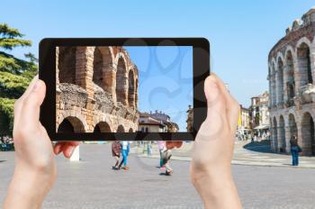 travel concept - tourist photographs roman Arena on Piazza Bra in Verona in spring in Italy on tablet
