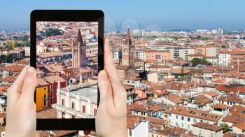 travel concept - tourist photographs Verona town in Italy from tower Torre dei Lamberti in spring on tablet