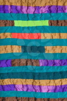textile background - stitched patchwork scarf from many narrow silk bands
