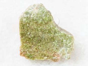 macro shooting of natural mineral rock specimen - green Vesuvianite crystals on raw stone on white marble background from Yakutia, Siberia, Russia