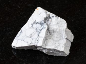 macro shooting of natural rock specimen - white Howlite stone on black granite background