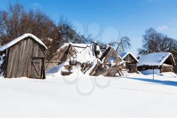 snow-covered old ruined courtyard in typical russian village in sunny winter day in Smolensk region of Russia