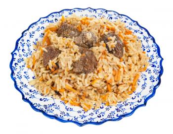 above view of prepared pilau (central asian dish from rice with meat and vegetable) on local ceramic plate isolated on white background