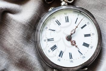 vintage pocket watch on gray textile background close up