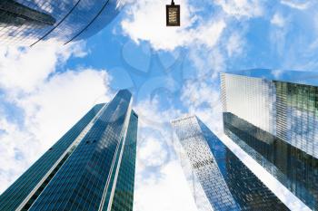 autumn blue sky with white clouds between glass skyscrapers in business district of Moscow city