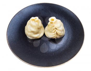 two steamed Buuz (Mongolian dumpling filled with minced meat) on dark brown plate isolated on white background