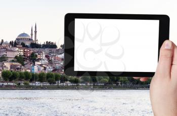 travel concept - tourist photographs of quayside in Fatih district in Istanbul city in Turkey in spring evening on smartphone with empty cutout screen with blank place for advertising