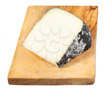 piece of local italian Perla Nera sheep's milk cheese on olive wood cutting board isolated on white background