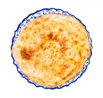 top view of freshly baked tandoor uzbek bread (Obi non) on ornamental plate isolated on white background