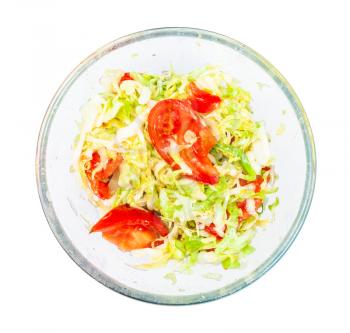 top view of vegetable salad from fresh chopped tomatoes and shredded cabbage in glass bowl isolated on white background