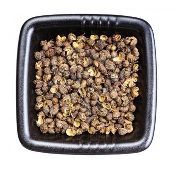 top view of dried sichuan pepper peppercorns in black bowl isolated on white background