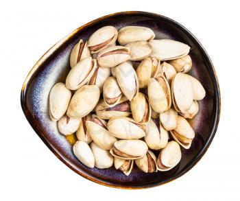 top view of raw ripe pistachio nuts in ceramic bowl isolated on white background