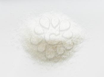 top view of pile of white refined beet sugar close up on gray ceramic plate