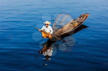 Myanmar travel attraction landmark - Traditional Burmese fisherman at Inle lake, Myanmar famous for their distinctive one legged rowing style