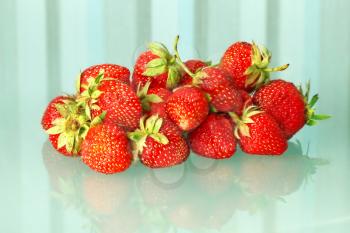 Heap of red fresh strawberries on a transparent blue striped background.