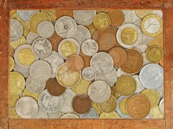 Old wooden frame with numismatic coins collection inside as abstract background.