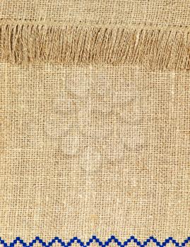 Natural linen texture pattern with fringe taken closeup as background.