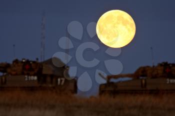 Armored vehicles under a full moon