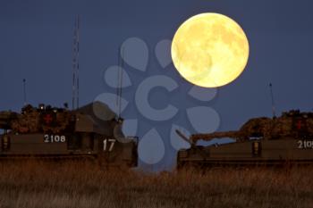 Armored vehicles under a full moon