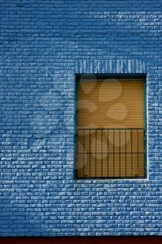 old yellow window in light blue wall in the centre of la boca buenos aires argentina 