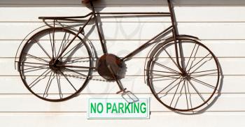  a no parkin signal in the garage door    and antique bicycle hanging 