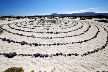 spain  hill white  beach  spiral of black rocks in the   lanzarote 

