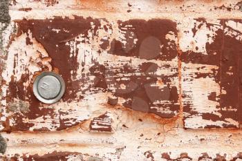 Fragment of old brick walls covered with red paint and with metal rods as bonding