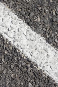 Fragment of asphalt pavement with white strip of road marking