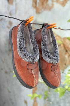Pair of male slippers hanging on a wire outdoors