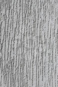 Fragment of a relief plaster walls grey color close-up as a texture, vertical