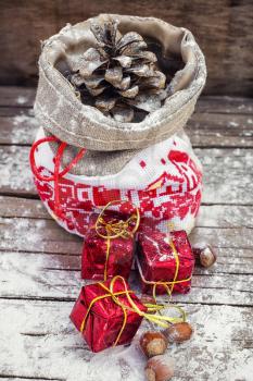 Symbolic Christmas bag with pine cones and three gift boxes