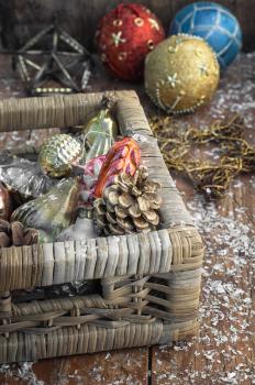 Braided straw basket full of cones and Christmas ornaments.