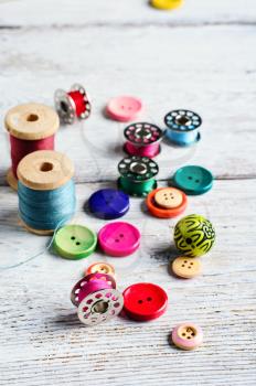Threads and a set of buttons and bobbin on a bright light background