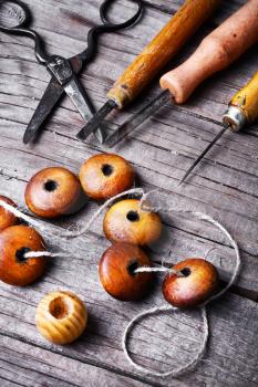 Accessories craft with wooden beads and tools on wooden background