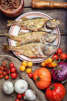 Dish of fried perch and vegetables on rustic recipe