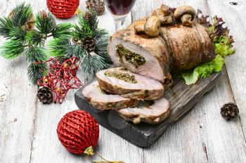 Dish of roulade of veal stuffed with mushrooms and spices and Christmas decorations