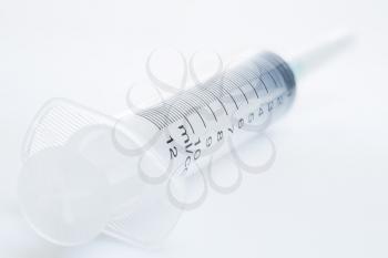 Plastic syringe isolated on a white background, high depth of field, close-up studio shot