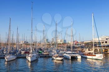 Sailing yachts and pleasure boats are moored in Barcelona port