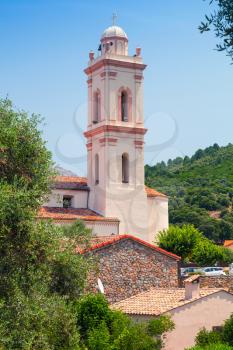 Small Corsican town vertical landscape, old living houses with red tile roofs and bell tower. Piana, South Corsica, France