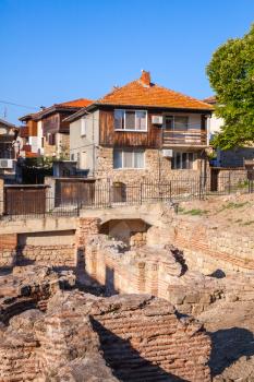 Street view of Nesebar, Bulgaria. Typical revival houses and ancient ruins in the old town. Vertical photo