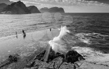 Stone breakwater with big waves. Montenegro, Adriatic Sea