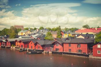Old red wooden houses on river coast. Porvoo, small historical town in Finland. Vintage tonal correction photo filter effect