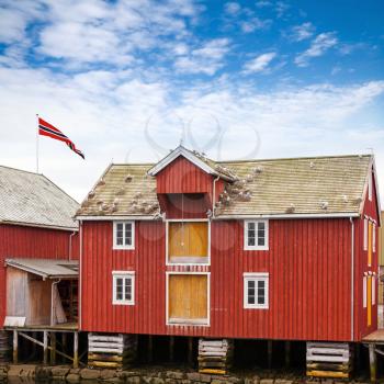 Red and yellow wooden coastal house in Norwegian fishing village. Rorvik, Norway
