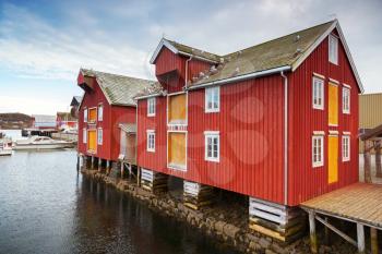 Red and yellow wooden coastal houses in Norwegian fishing village. Rorvik, Norway