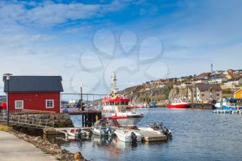 Small Norwegian village landscape, wooden houses and moored fishing boats on the North sea coast 